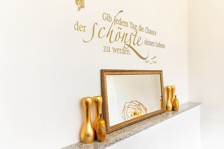 Wandspruch in Gold über einem Spiegel im Studio